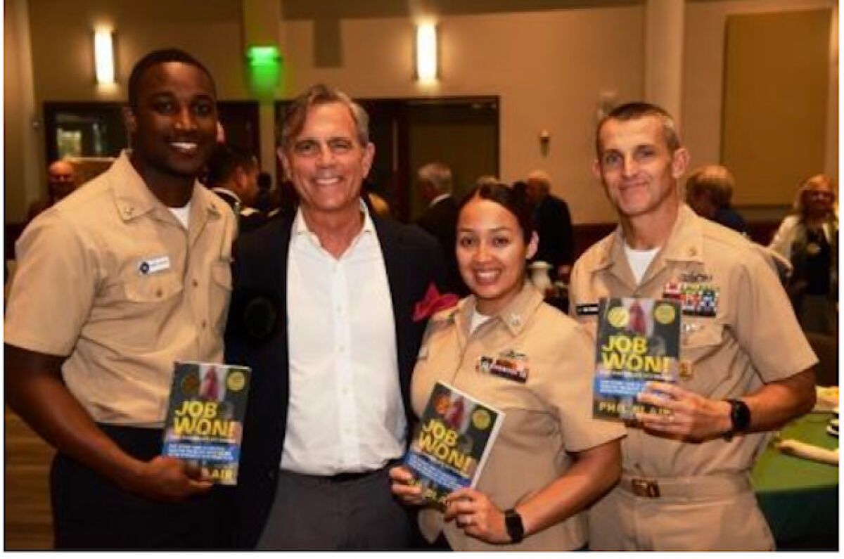 Phil Blair, second from left, is pictured with three U.S. service members displaying the Del Mar resident’s book, “Job Won! For America’s Veterans”.