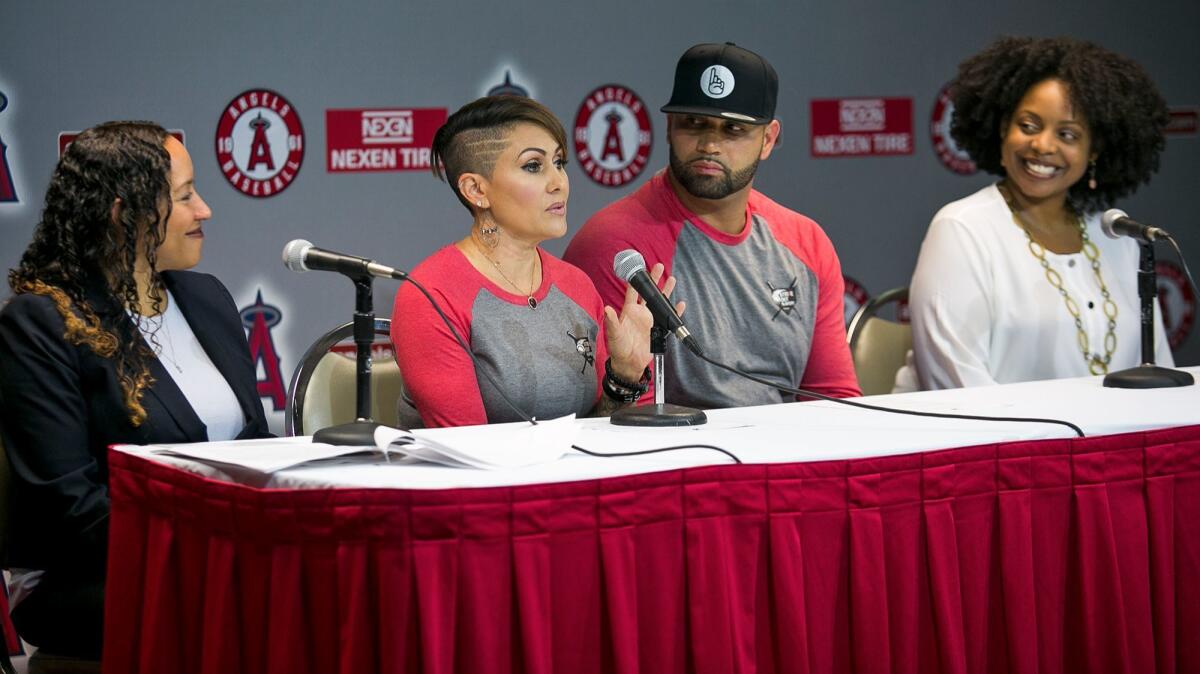 Deidre Pujols speaks as husband Albert looks on during a news conference about "Strike Out Slavery" at Angel Stadium on Aug. 24.