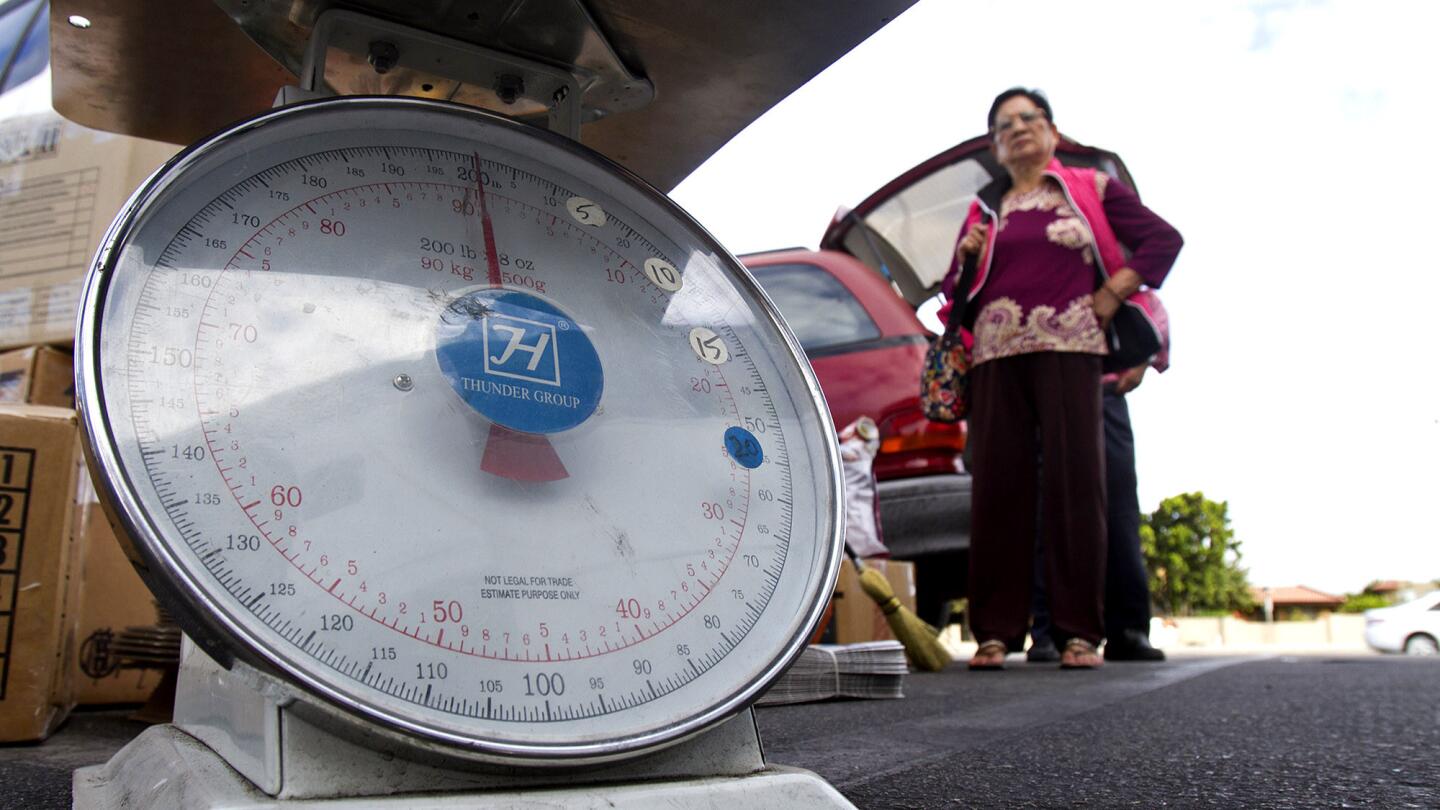 A package is weighed before being transported to San Jose on the Xe Do Hoang bus line. The passenger ticket price -- $40 each way -- includes a banh mi sandwich and a bottle of water.