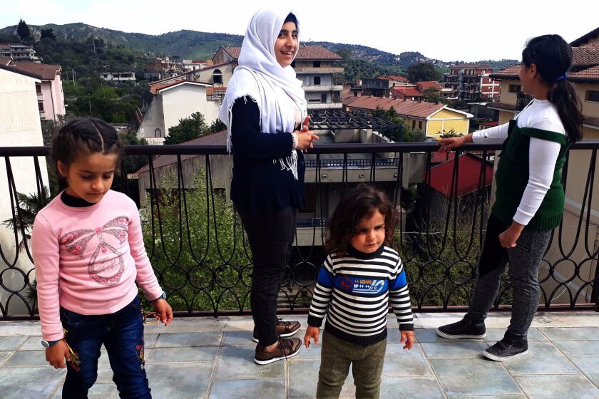 (left to right) Ghima, 7; Mais, 15; Bader, 2; and Ghazal, 14, stand on the rooftop terrace in their family's new home in the southern Italian town of Gioiosa Ionica. The children and their parents, Mohammed Ali and Kinda Nonoo, fled Aleppo for Lebanon five years ago, and traveled to Italy in February via the "humanitarian corridors" project set up by church-affiliated organizations to bring Syrian refugees from Lebanon to Italy.