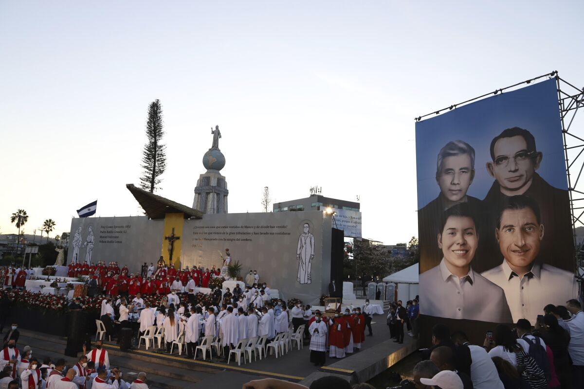 FILE - A poster depicting the Rev. Rutilio Grande, Franciscan priest Cosme Spessotto, Nelson Lemus and Manuel Solorzano, all victims of right-wing death squads during El Salvador's civil war, is displayed during their beatification ceremony in San Salvador, Saturday, Jan. 22, 2022. (AP Photo/Salvador Melendez, File)