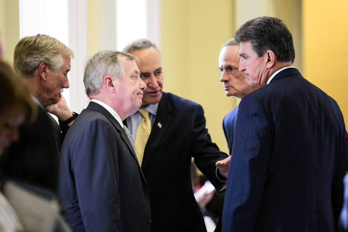 Sens. Angus King (I-Maine), left, Richard Durbin (D-Ill.), Charles Schumer (D-N.Y.), Thomas Carper (D-Del.) and Joe Manchin III (D-W.Va.) confer after a closed-door meeting with other Democratic senators on Capitol Hill.