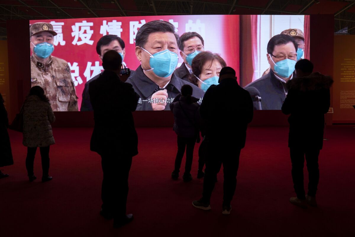 People stand before a large video screen