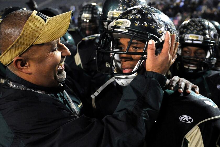 Narbonne Coach Manuel Douglas, left, hugs Tray Boone after the running back scored six touchowns in a win over Carson in the City Section championship game on Dec. 9, 2011.