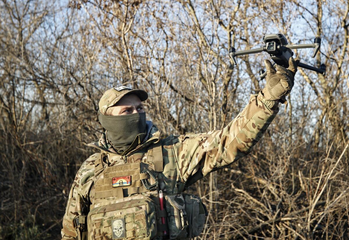 Ukrainian serviceman holding up a drone