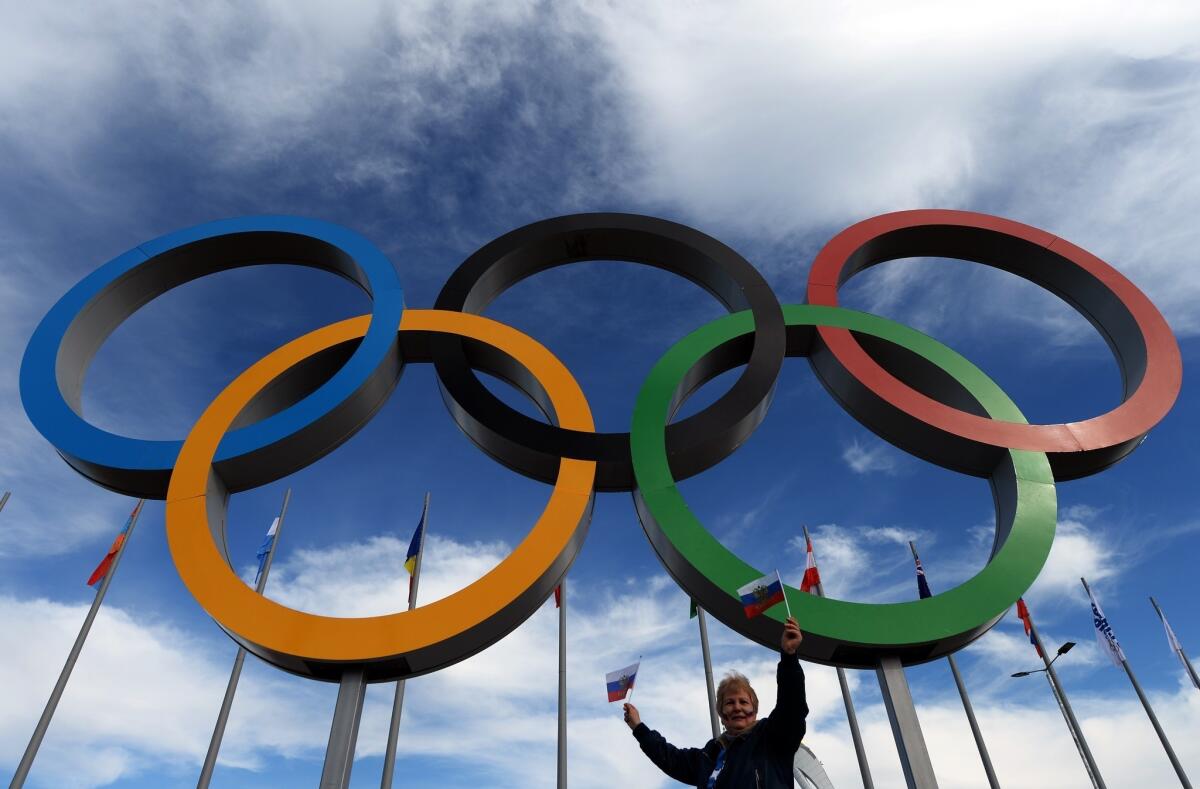 A woman poses under the Olympic rings during the Winter Games in Sochi, Russia.