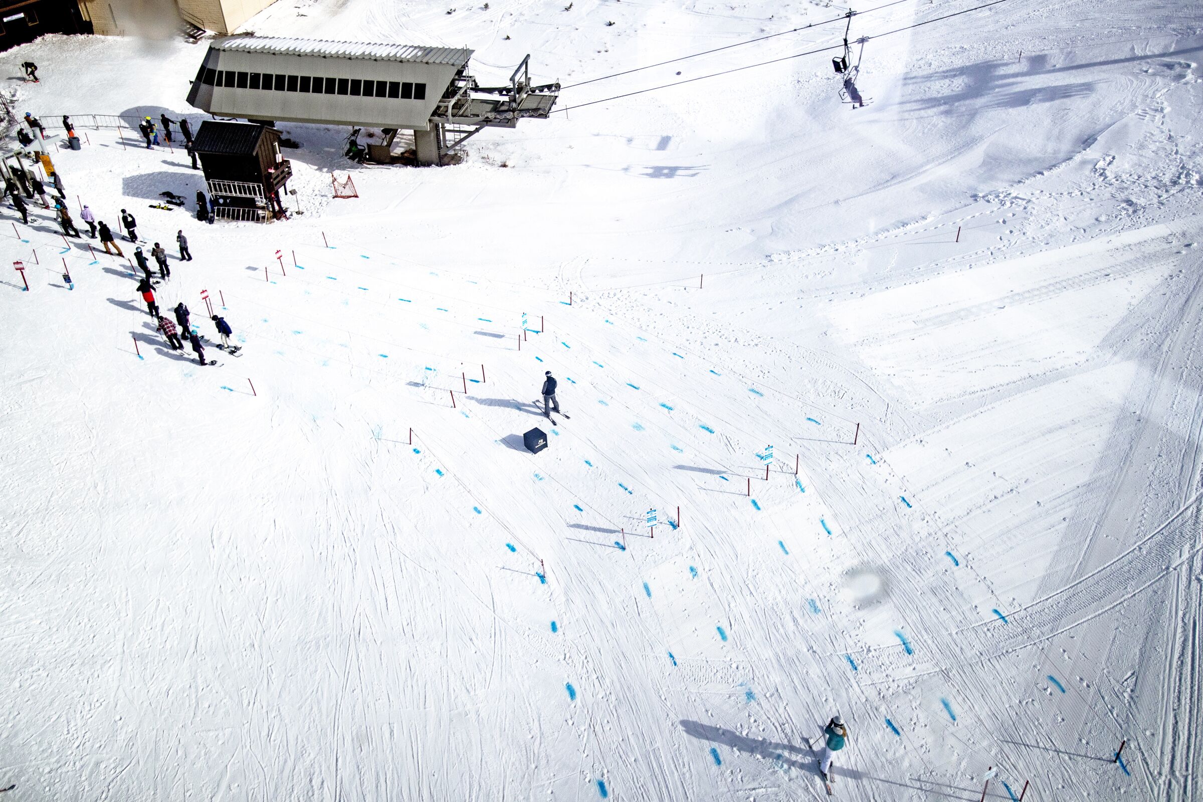 Blue dye in the snow at Mammoth Mountain marks physical distancing.