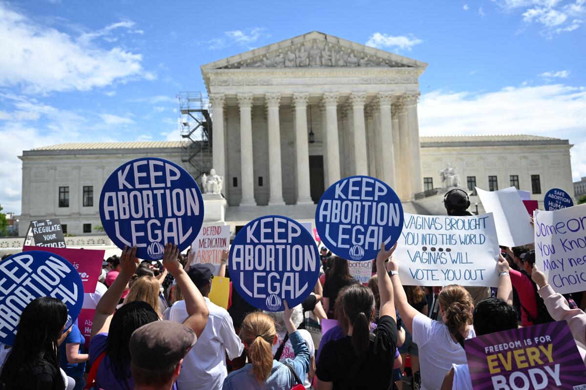 A crowd of people outside the U.S. Supreme Court building raising signs, many reading "Keep abortion legal."