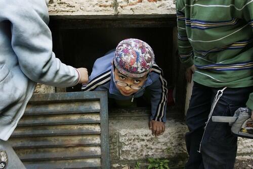 A Jewish boy climbs out of the air shaft of a shelter during a drill in a school in Jerusalem.