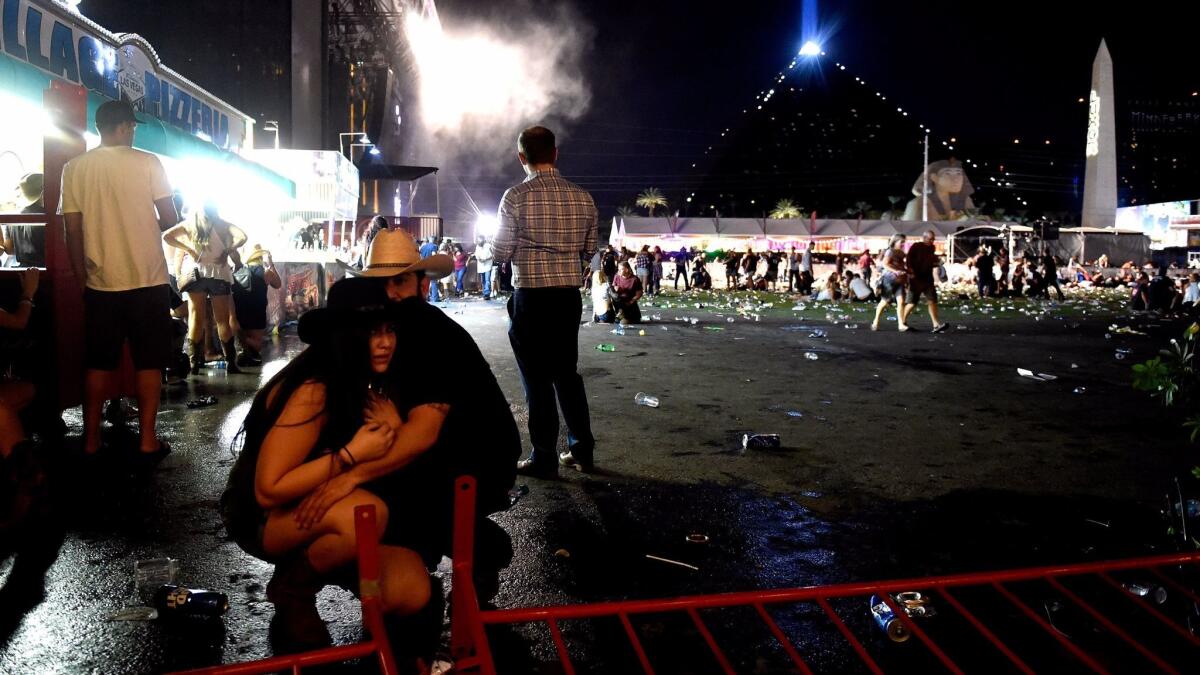 People take cover at the Route 91 Harvest country music festival after gunfire was heard in Las Vegas.