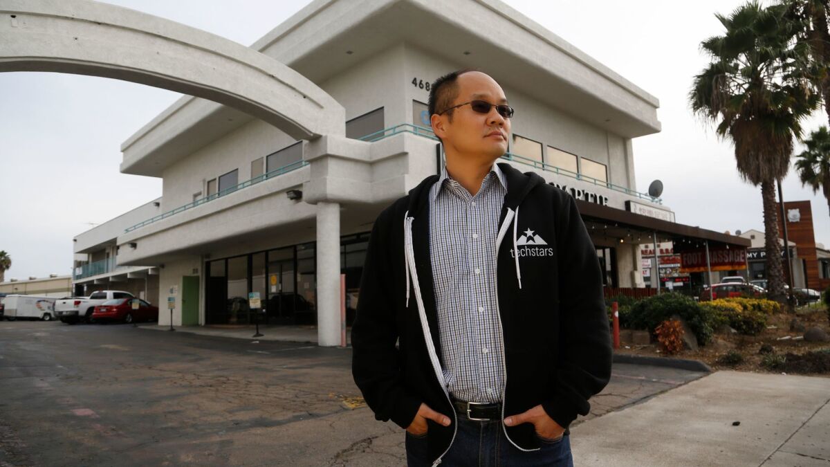 Ping Wang stands near the business building where his family once owned bakery as well as a landlord to other businesses that operated from their building.