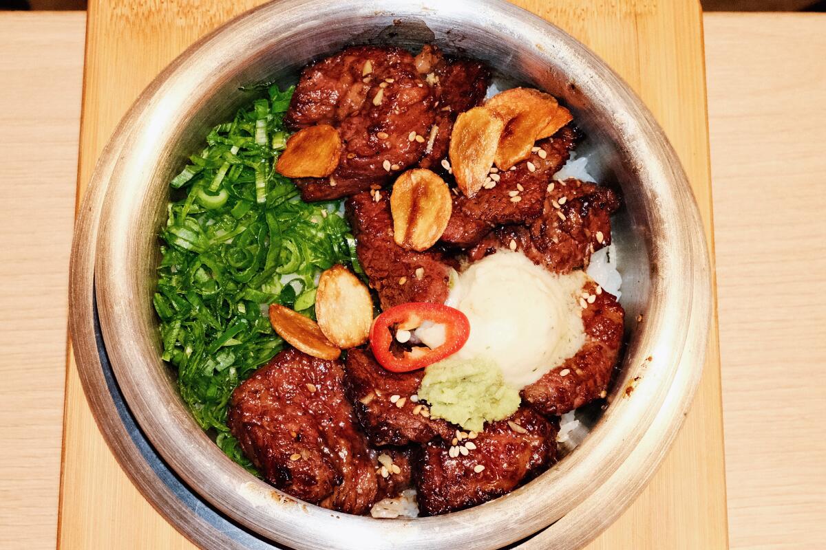 Pot rice topped with seasoned beef short ribs, herbs, garlic and butter at Lasung Tofu & Pot Rice in Koreatown.