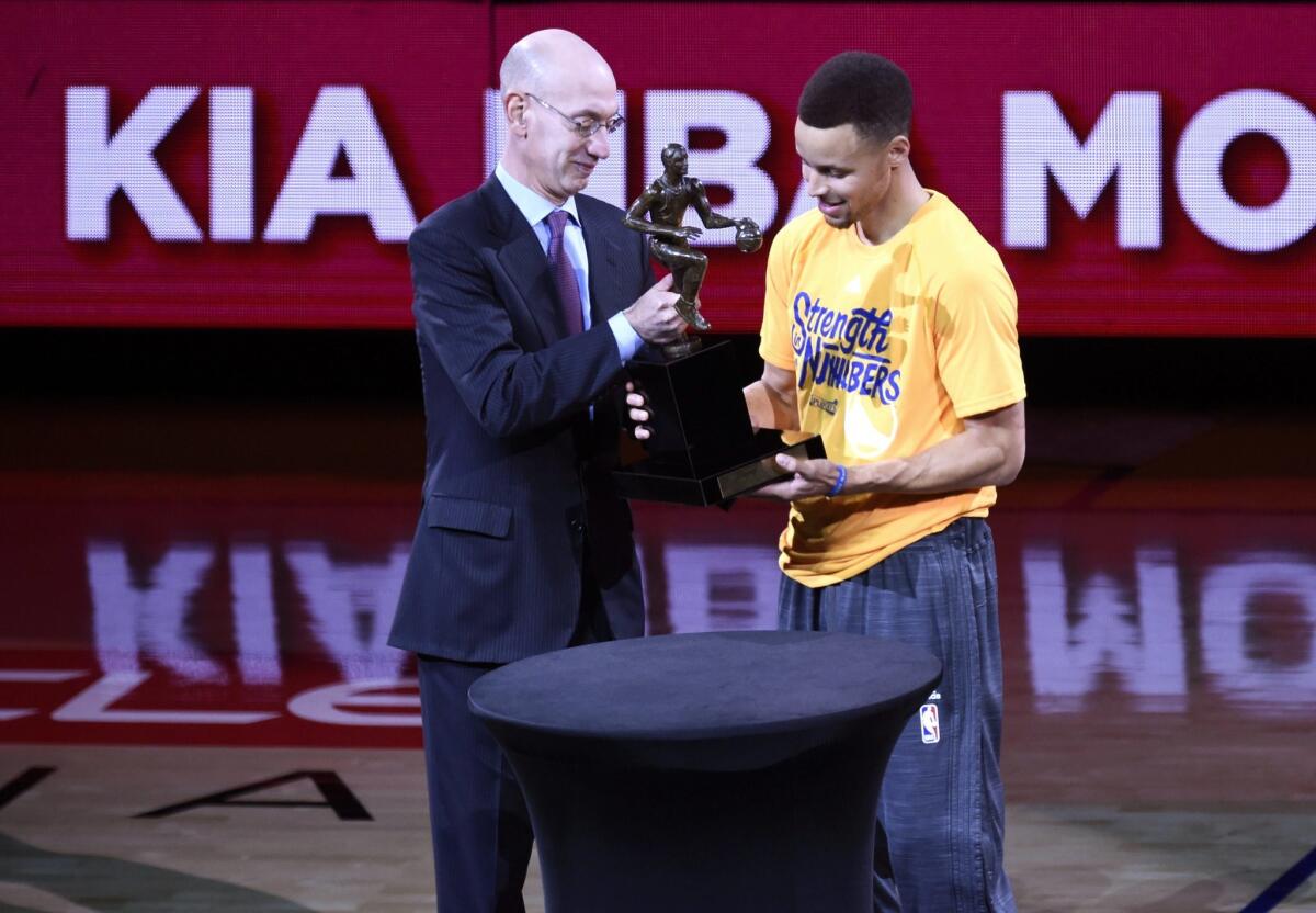 Golden State's Stephen Curry receives the MVP award from NBA Commissioner Adam Silver.