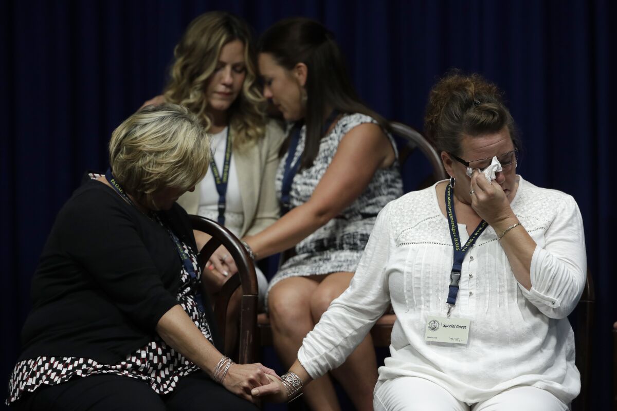 Victims of clergy sexual abuse and their family members react as Pennsylvania Atty. Gen. Josh Shapiro speaks in August 2018.