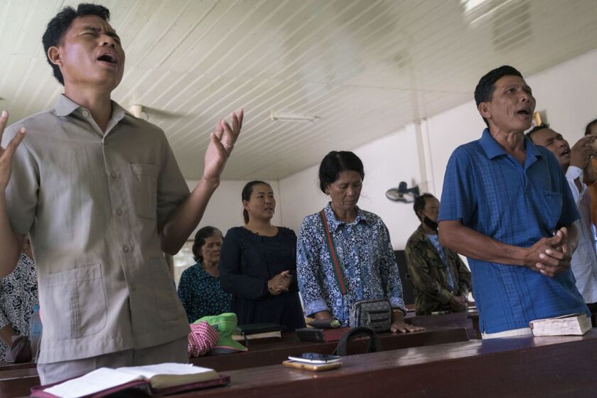 Norng Chhay, right, in blue shirt, participates in a Sunday service at the Pailin's B.P. Presbyterian Church. Norng was a Khmer Rouge soldier for almost 20 years. He converted to Christianity in 2000.