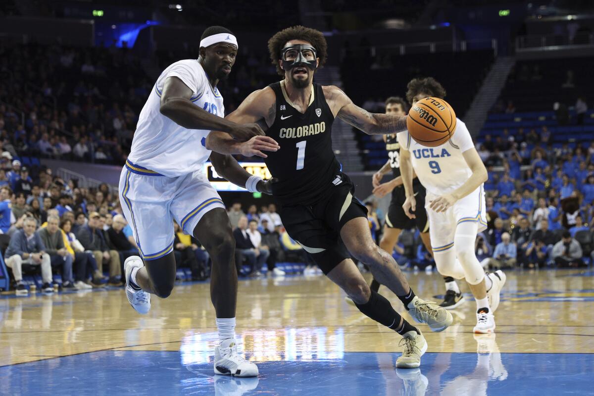 Colorado guard J'Vonne Hadley, right, drives past UCLA forward Adem Bona during the first half Thursday.