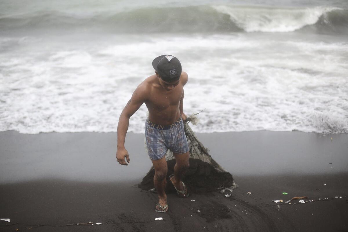 A man drags sand that he cleared from his house on Dec. 8 after Typhoon Hagupit battered a coastal village in Albay province, the Philippines.