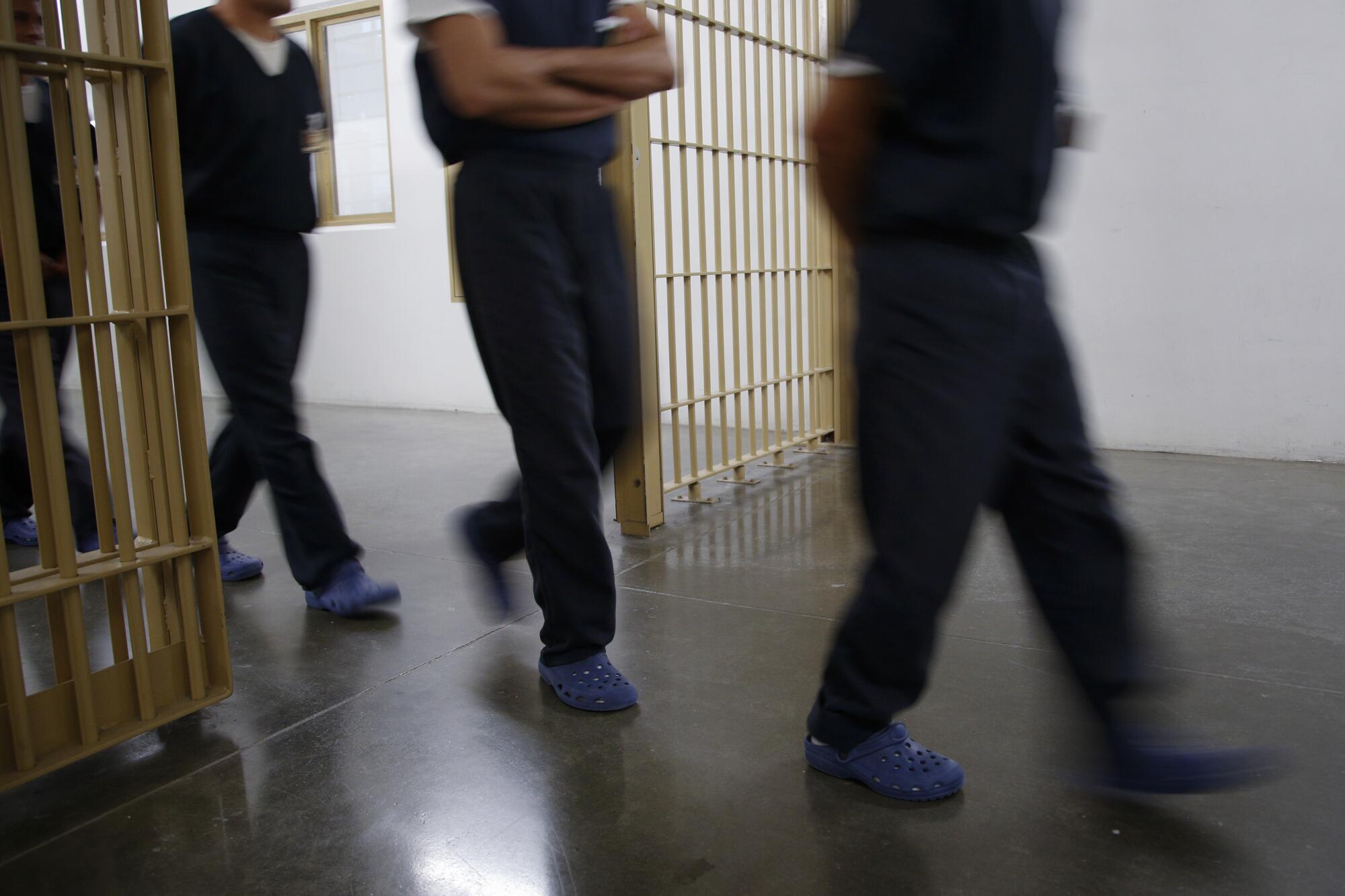 Detainees walk through a metal gate at Otay Mesa Detention Center in San Diego.