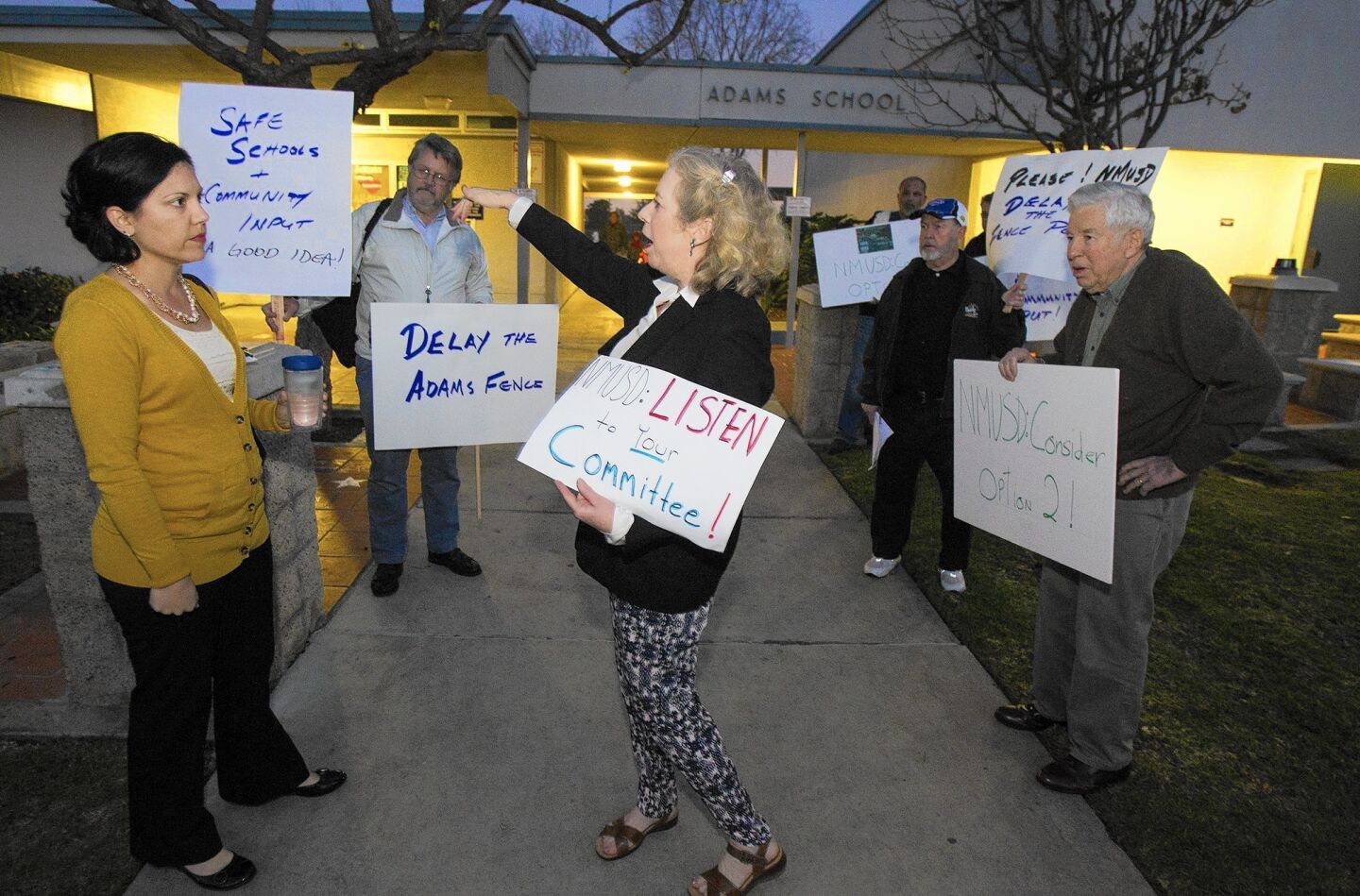 DP No. 10 Kathy Esfahani: Alison Walske, left, a 5th grade teacher at Adams Elementary, and Kathy Esfahani exchange words during a communtiy protest regarding the decision by Newport Mesa Unified School District to put a fence around the school on Feb. 5.