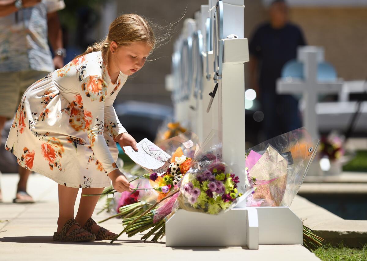 An 8-year-old places flowers at a memorial