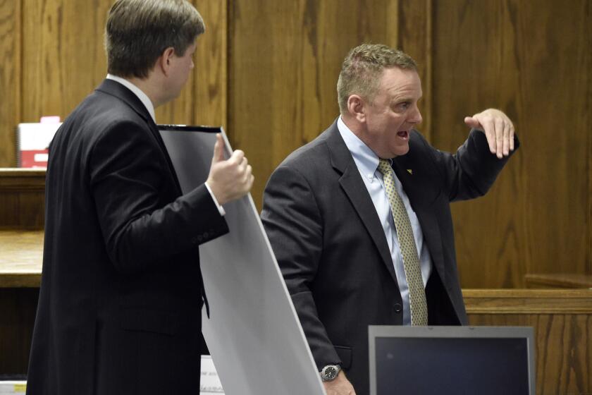 Erath County Dist. Atty. Alan Nash, left, holds evidence as forensics expert Howard J. Ryan testifies during the murder trial of former Marine Cpl. Eddie Ray Routh in Stephenville, Texas.