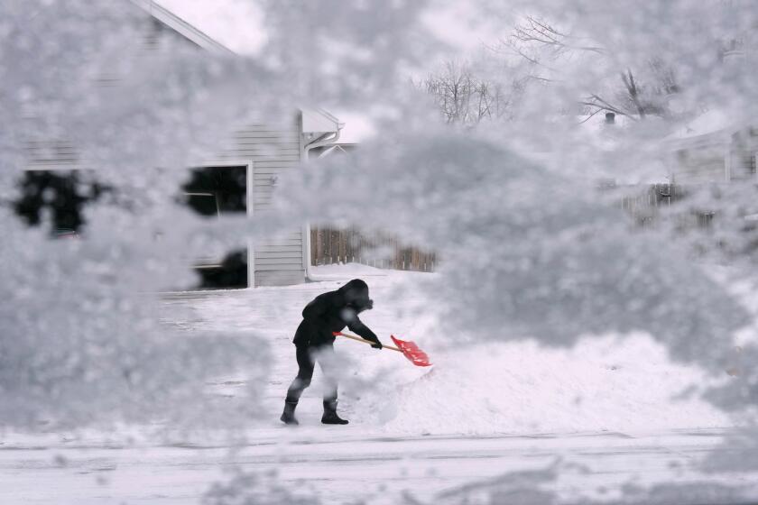 A local resident shovels snow off the end of a driveway, Thursday, Dec. 22, 2022, in Urbandale, Iowa. Temperatures plunged far and fast Thursday as a winter storm formed ahead of Christmas weekend, promising heavy snow, ice, flooding and powerful winds across a broad swath of the country and complicating holiday travel. (AP Photo/Charlie Neibergall)