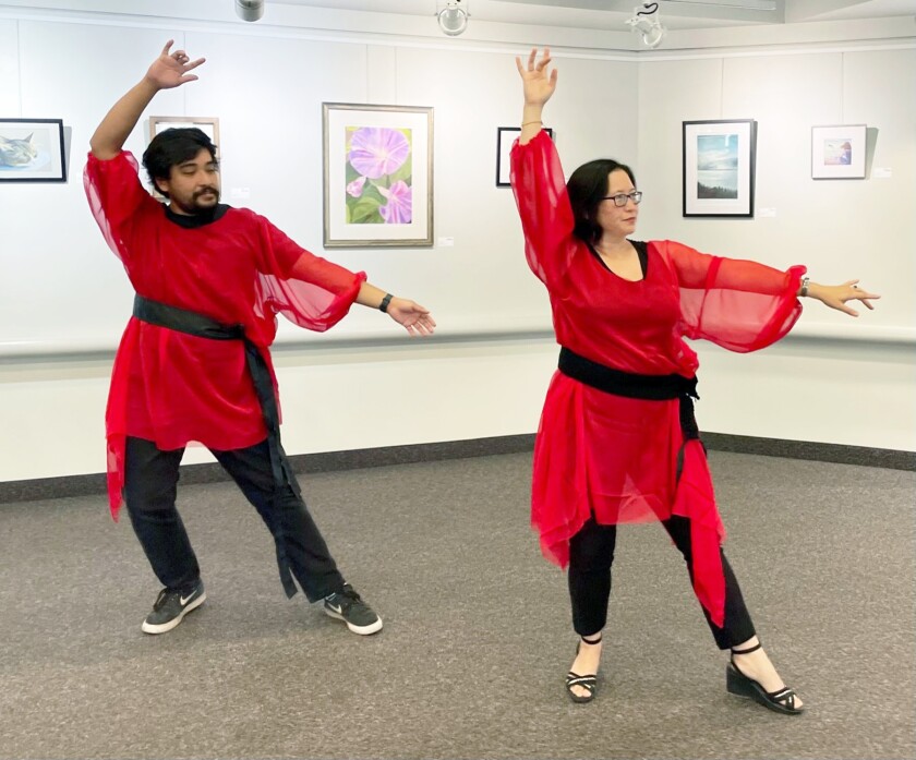 Library staff members Rob Rosas and Christina Wainwright rehearsing the “Wuthering Heights” dance in the red tunics.