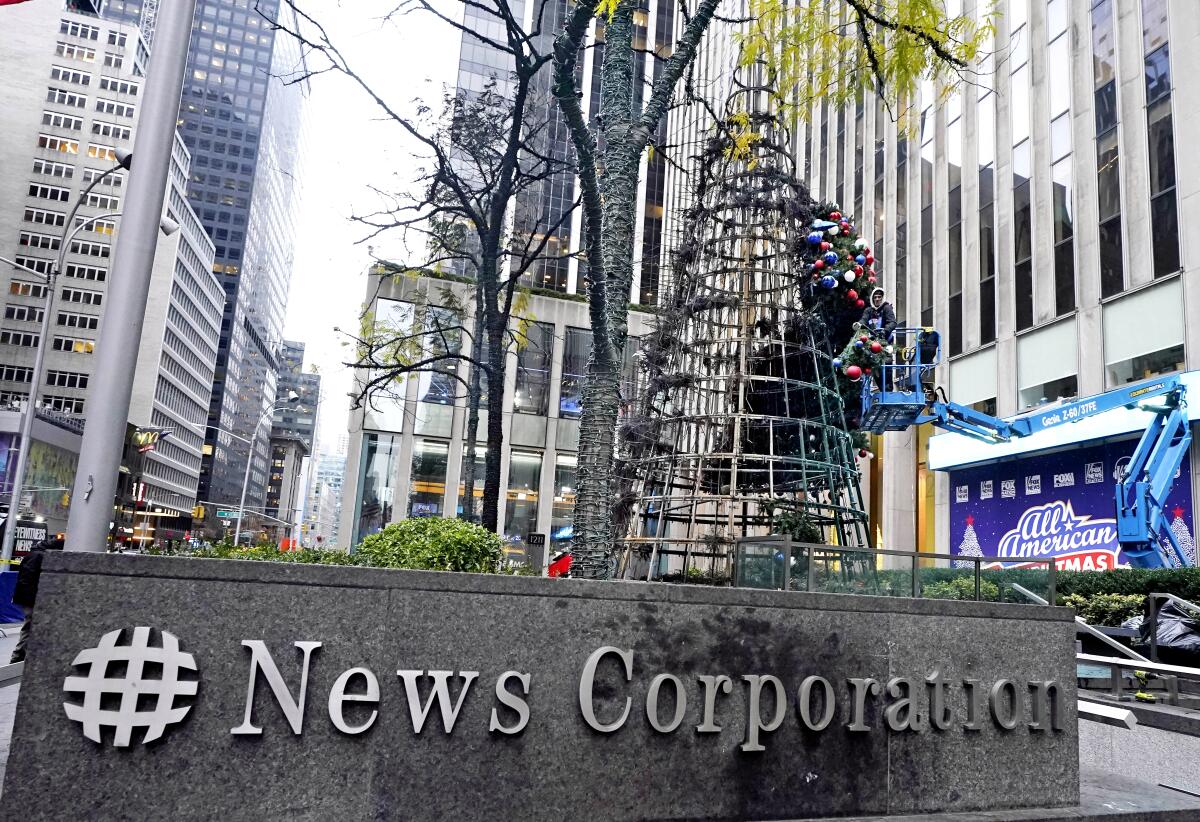 A worker disassembles a Christmas tree outside Fox News' headquarters in New York.