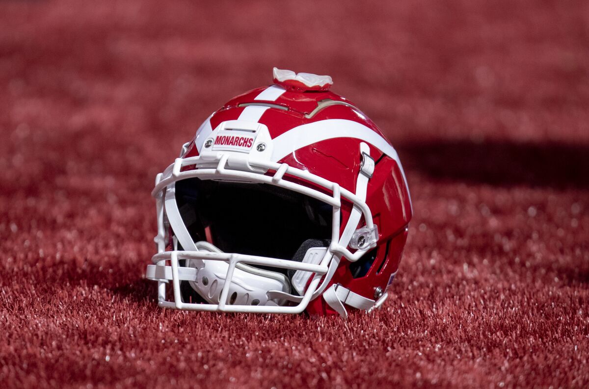 A Mater Dei football helmet rests on the turf in an end zone.