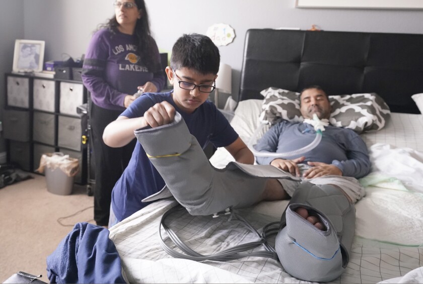 Ronan Kotiya, 11, removes a compression leg sleeve from his father Rupesh Kotiya.