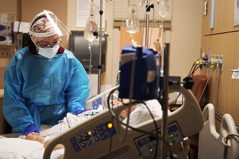 Registered nurse Melanie LaMadrid tends to a COVID-19 patient at Providence Holy Cross Medical Center in the Mission Hills section of Los Angeles.