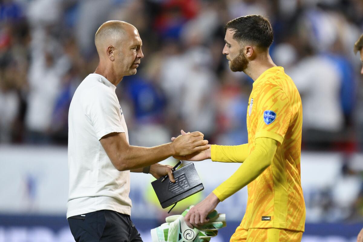 U.S. men's soccer coach Gregg Berhalter, left, shakes hands with goalkeeper Matt Turner.