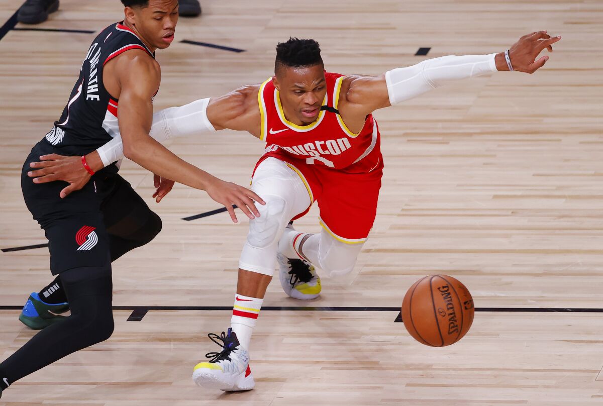 Anfernee Simons, left, of the Portland Trail Blazers knocks the ball away from Russell Westbrook, right, of the Houston Rockets during the first half of an NBA basketball game Tuesday, Aug. 4, 2020, in Lake Buena Vista, Fla. (Kevin C. Cox/Pool Photo via AP)