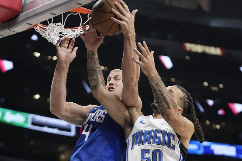 Los Angeles Clippers center Mason Plumlee, left, and Orlando Magic guard Cole Anthony reach for a rebound during the second half of an NBA basketball game Tuesday, Oct. 31, 2023, in Los Angeles. (AP Photo/Mark J. Terrill)