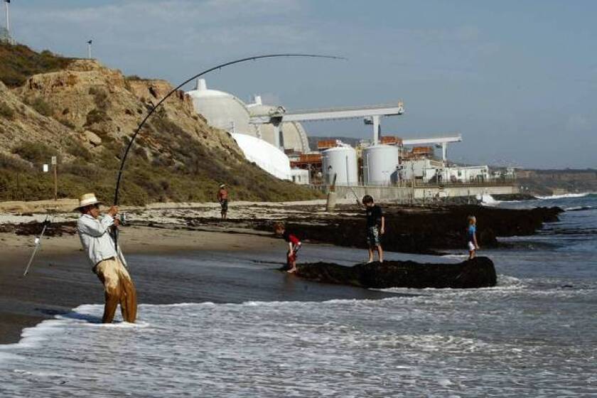 People play at the beach near the San Onofre Nuclear Generating Station in northern San Diego County. The plant has been shut down since January in the wake of equipment problems that caused a release of radioactive steam into the atmosphere.