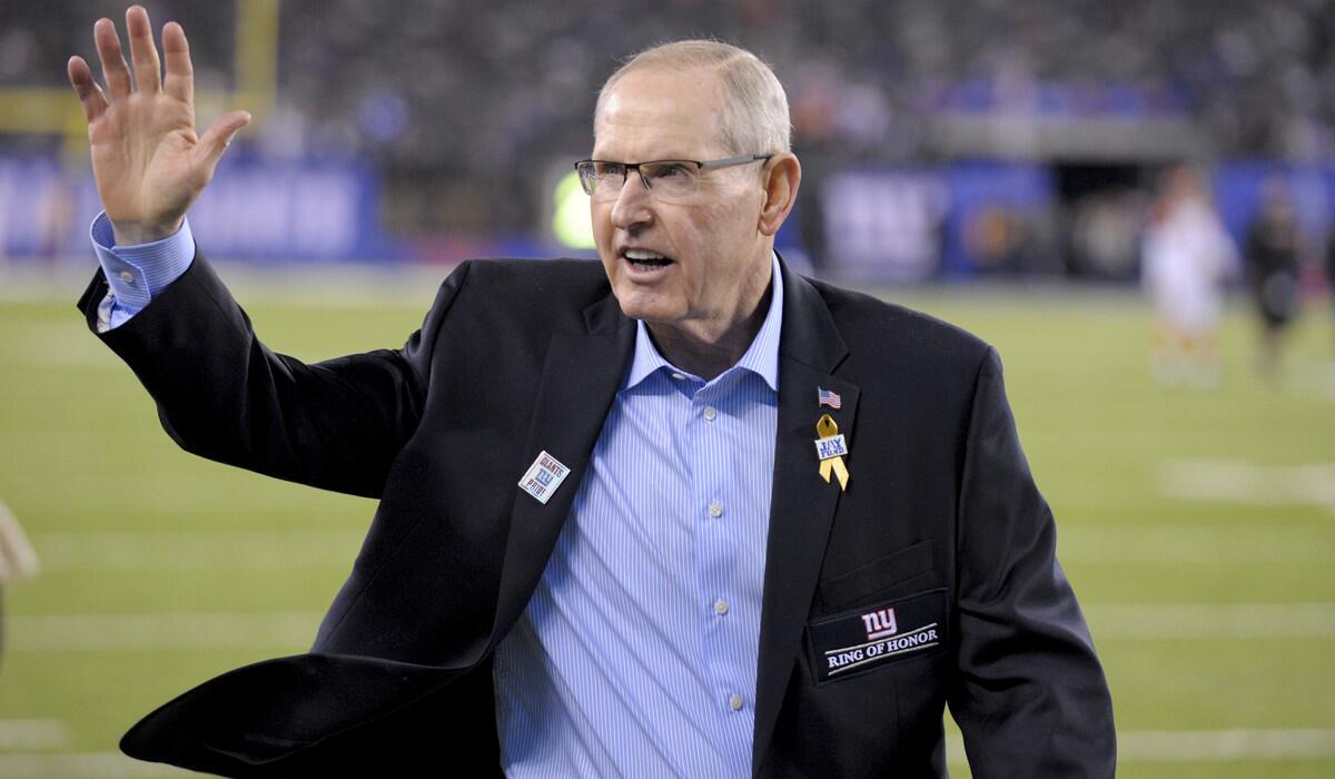 Former New York Giants coach Tom Coughlin waves to fans as he walks on the field before an NFL game between the New York Giants and the Cincinnati Bengals on Nov. 14.
