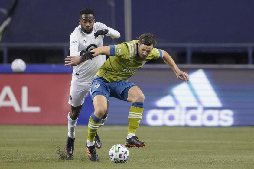 Minnesota United midfielder Kevin Molino, left, and Seattle Sounders midfielder Gustav Svensson vie for the ball during the second half of an MLS playoff Western Conference final soccer match, Monday, Dec. 7, 2020, in Seattle. (AP Photo/Ted S. Warren)