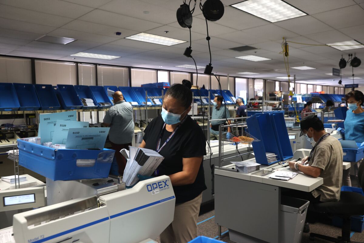 Workers sort mail-in-ballots at the Santa Clara County registrar of voters office on Aug. 25 in San Jose.