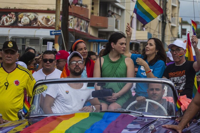 FILE - In this May 12, 2018 file photo, Mariela Castro, daughter of Raul Castro and director of Cuba's National Center for Sexual Education, waves a rainbow flag while sitting in a convertible car during the annual Gay Pride parade in Havana, Cuba. Castro said Tuesday, May 7, 2019, that the Cuban government has cancelled the Conga Against Homophobia parade, that was widely seen as a sign of progress on gay rights. (AP Photo/Desmond Boylan)