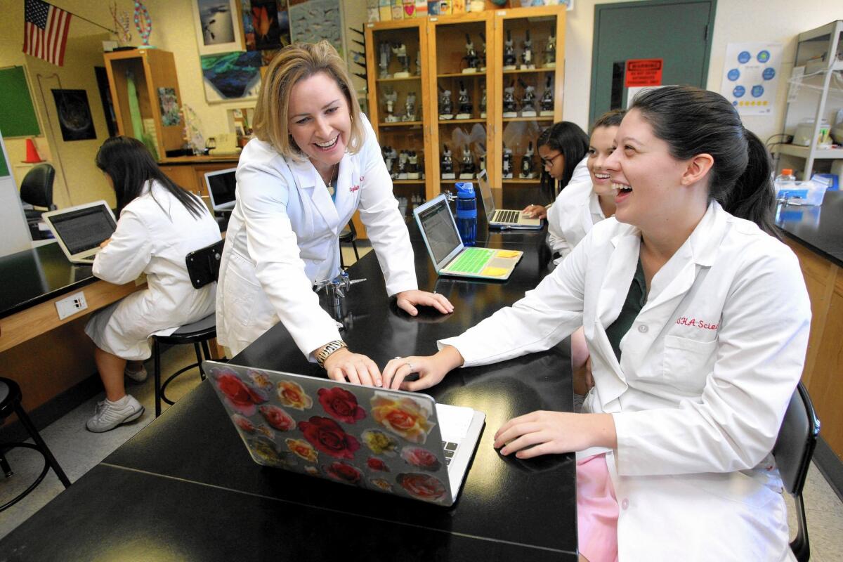 Flintridge Sacred Heart Academy science teacher Dr. Elizabeth Krider, left, goes over potential subjects of study with senior Danielle Fradet, right, in the honors scientific research class at the La Cañada Flintridge school on Friday, Sept. 25, 2015.