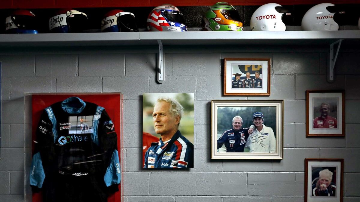 Helmets, race suits and photographs are among the Paul Newman memorabilia in Adam Carolla's garage.