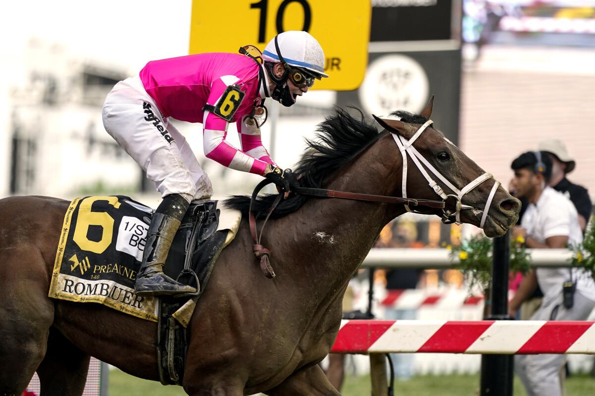 Flavien Prat atop Rombauer reacts as he crosses the finish line to win the 2021 Preakness Stakes.