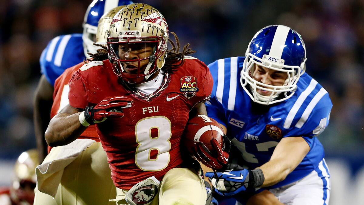 Florida State's Devonta Freeman carries the ball during the Seminoles' win in the Atlantic Coast Conference championship game over Duke in December. The ACC will continue to have an eight-game conference schedule in 2014.