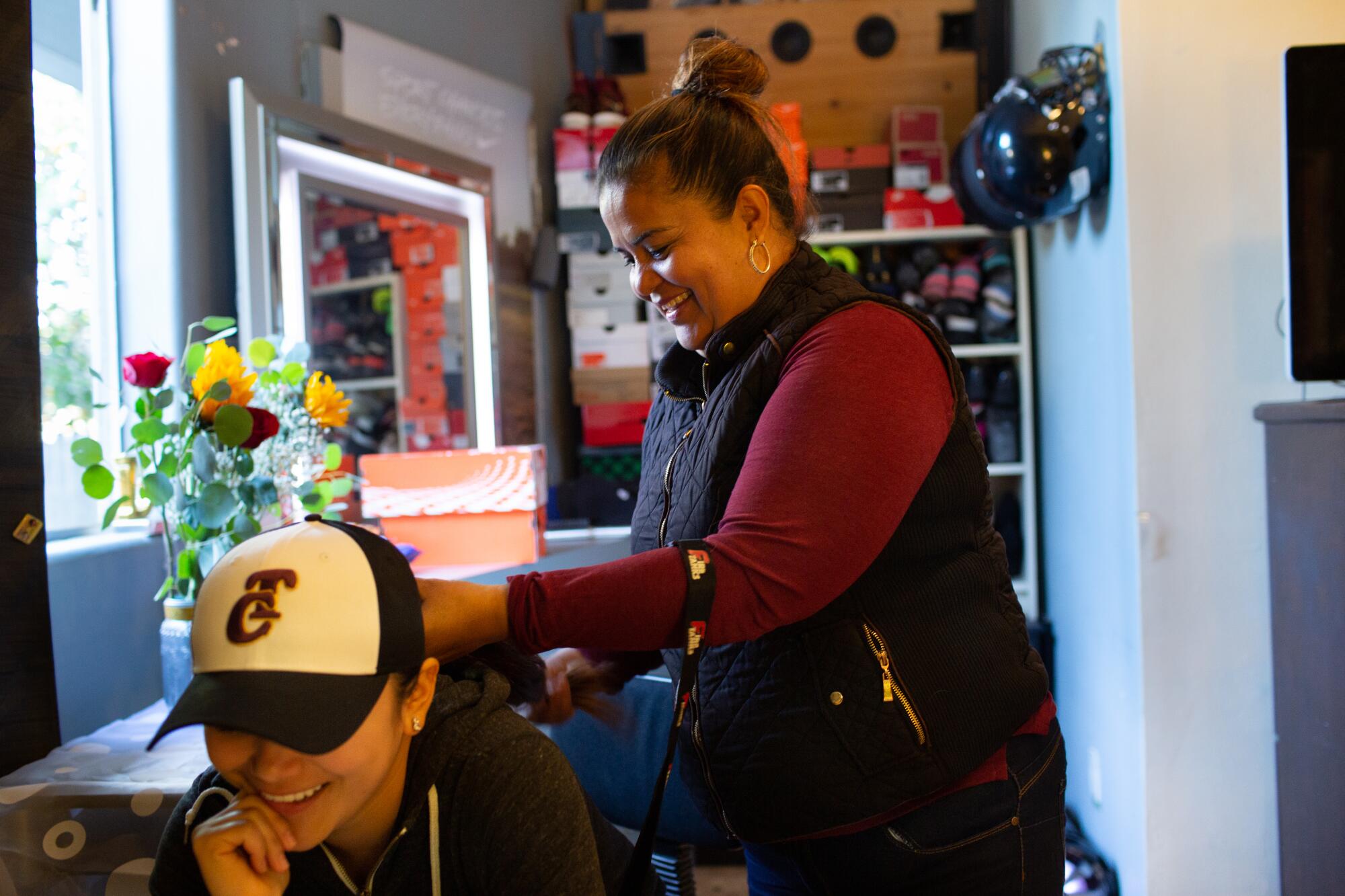 Dalia Hurtado has her hair braided by her abuela, Elizabeth Meza, before leaving to a catering job on Feb. 15, 2020. 