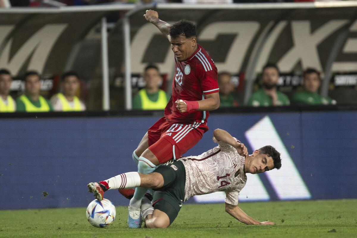 Mexico midfielder Rodrigo López challenges Colombia forward Roger Martínez.