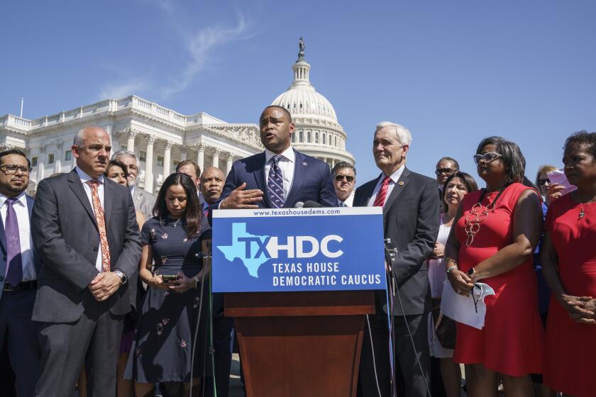 Rep. Marc Veasey, D-Texas, center, flanked by Texas State Rep. Chris Turner, left, chairman of the Texas House Democratic Caucus, and Rep. Lloyd Doggett, D-Texas, right, as Democratic members of the Texas legislature hold a news conference at the Capitol in Washington, Tuesday, July 13, 2021. (AP Photo/J. Scott Applewhite)