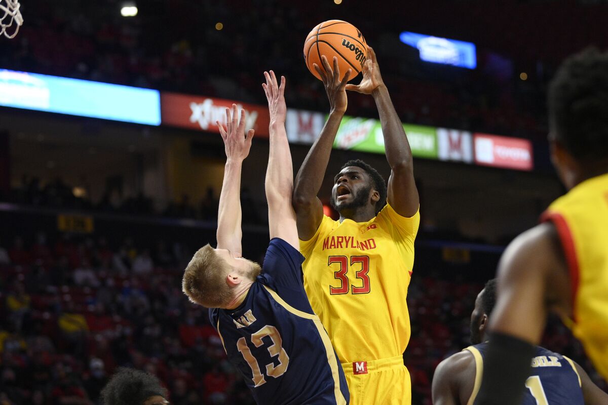 Maryland forward Qudus Wahab (33) goes to the basket against George Washington forward Hunter Dean (13) during the second half of an NCAA college basketball game, Thursday, Nov. 11, 2021, in College Park, Md. (AP Photo/Nick Wass)