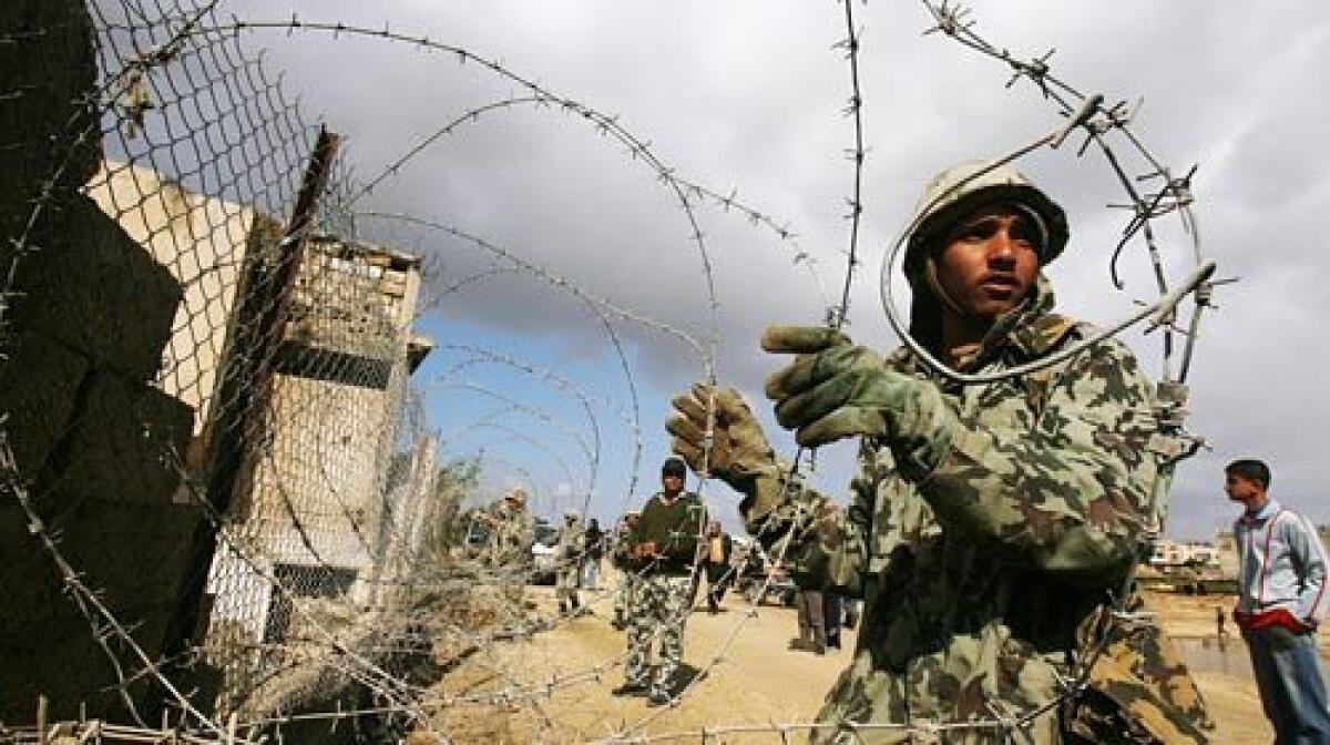 Egyptian soldiers use barbed wire to close a section of the border between the southern Gaza Strip town of Rafah and Egypt.