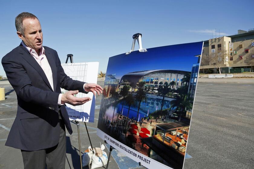 Chris Meany, senior vice president of Hollywood Park Land Co., unveils an architectural rendering of a proposed NFL stadium at Hollywood Park in Inglewood.