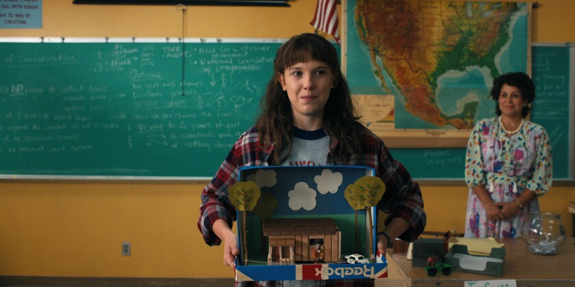 A teenage girl present a dioarama in class.